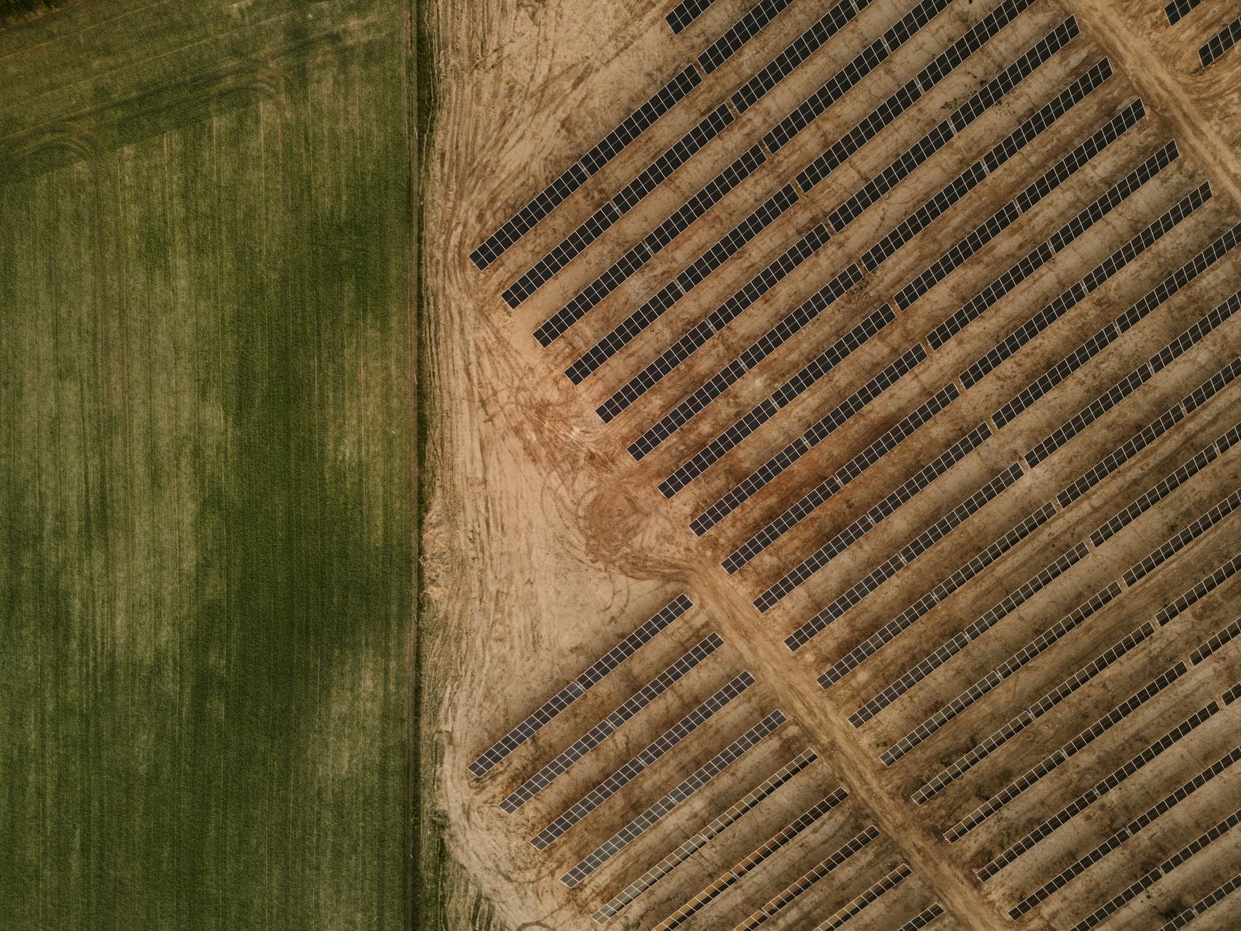 Aerial view of a solar farm beside cultivated farmland